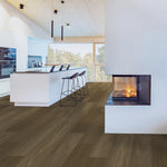 donker bruin eiken vloer met brede planken en subtiele houtnerfstructuur in moderne witte keuken met eiland en open haard