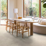 lichte tegelvloer met grote rechthoekige tegels in matte afwerking en zachte beige kleur met subtiel structuurpatroon in moderne eetkamer met houten tafel en rieten stoelen