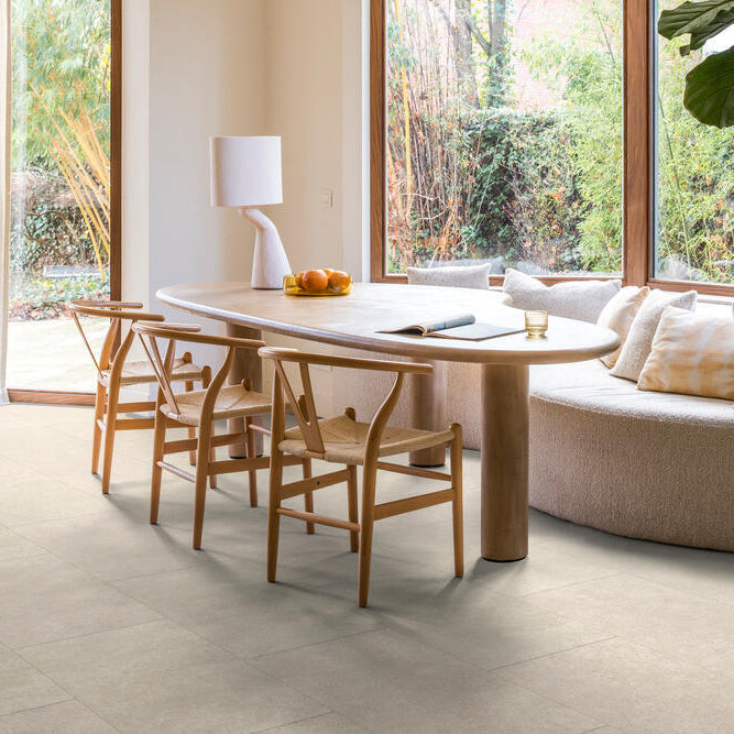 lichte tegelvloer met grote rechthoekige tegels in matte afwerking en zachte beige kleur met subtiel structuurpatroon in moderne eetkamer met houten tafel en rieten stoelen