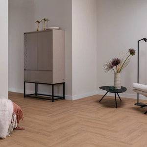licht eiken visgraatvloer met subtiele houtnerfstructuur en brede planken in een naturel beige tint