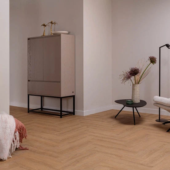 licht bruin houten vloer in visgraat patroon met subtiele houtnerf structuur in een sfeervolle woonkamer met beige muren en minimalistische meubels