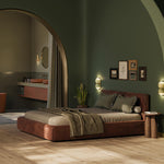 lichte beige eiken vloer met brede planken in rechte gelegd patroon in moderne slaapkamer met donkergroen geschilderde muren en rustbruin leren laag bed met gestreepte kussens