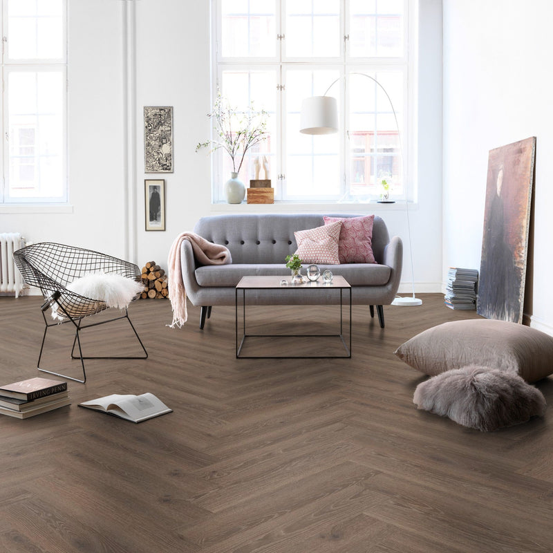 lichte bruin eiken visgraatvloer met fijne houtnerfstructuur in moderne woonkamer met grijs stoffen bank en designstoel